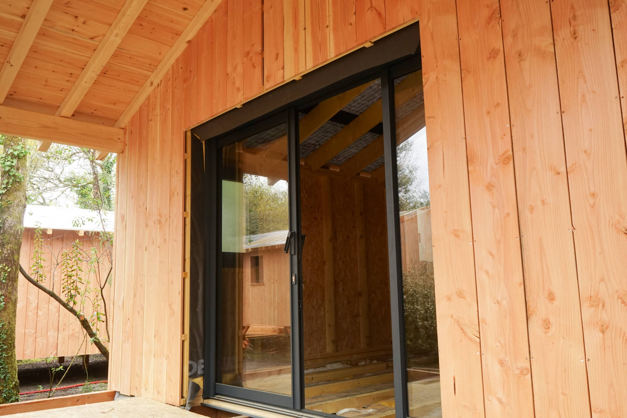 Baies vitrées alu et fenêtres PVC noires pour les chalets du Marache à Biganos
